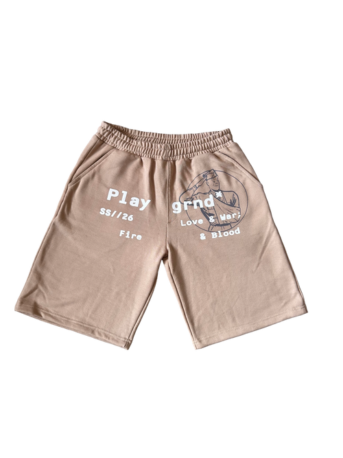 A pair of beige athletic shorts with a gray graphic print on the left leg and white text on the right leg, displayed flat against a white background.